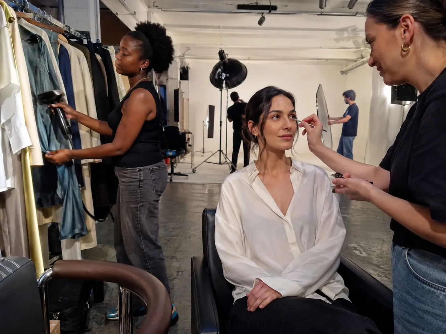 A photo of a make up artist doing the make up of a fashion model