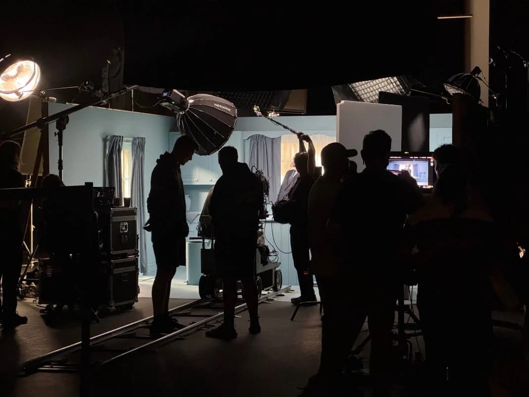 A film crew working around monitors and lighting on set