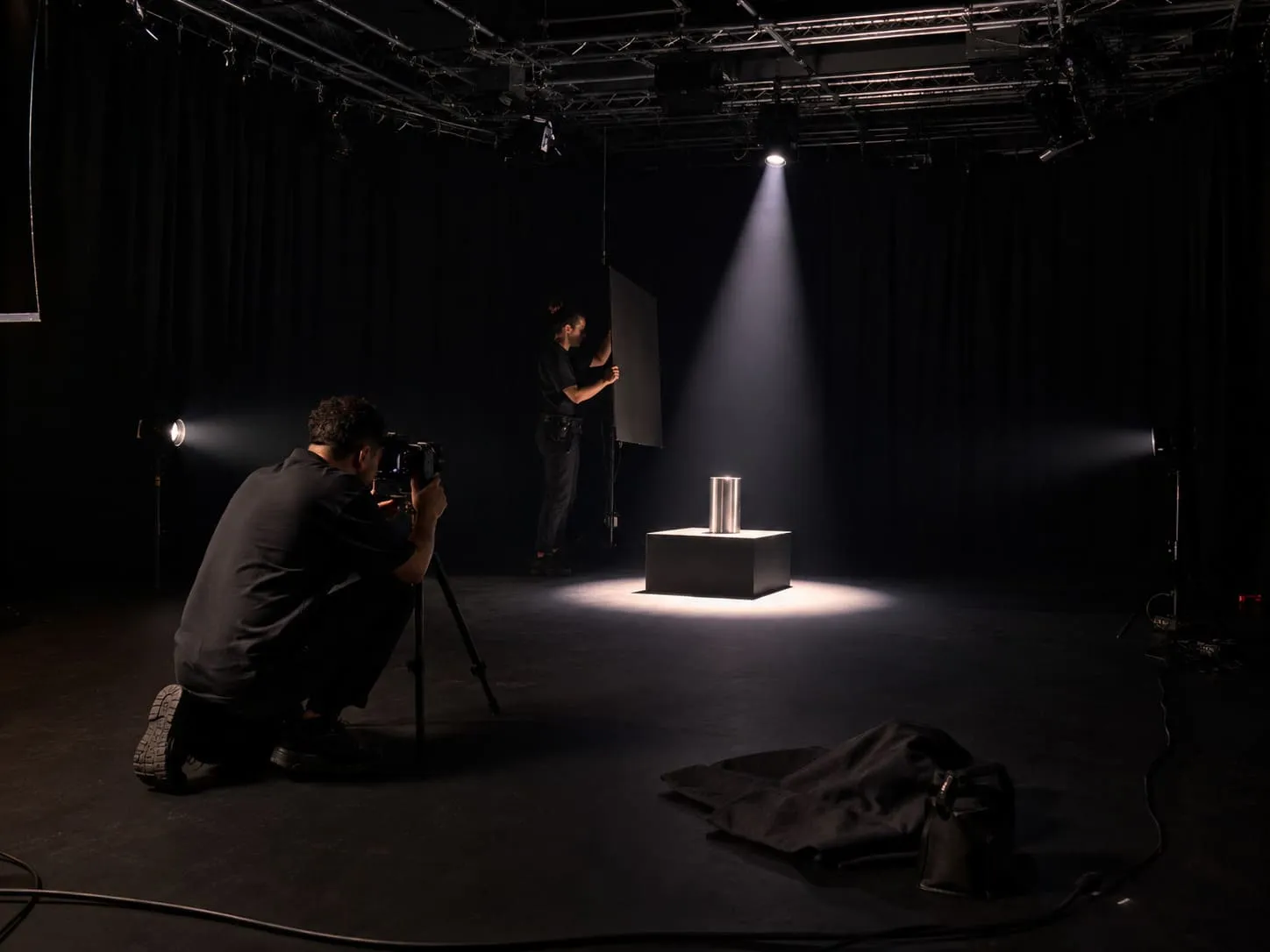 A blackout studio shoot for a high value product taking place with the light beaming on to the product