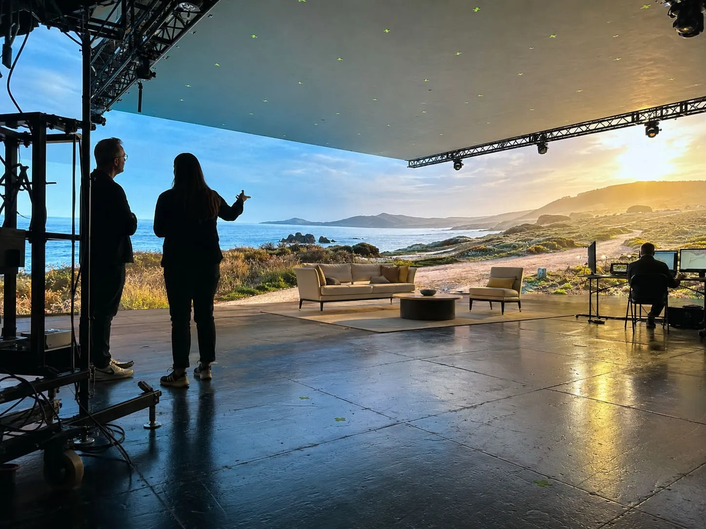 A film crew setting up lighting and camera equipment on a studio stage
