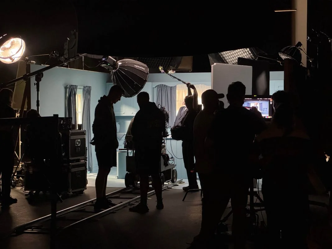A film crew working around monitors and lighting on set